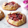 Mini gluten free strawberry rustic pies with a sprinkle of icing sugar