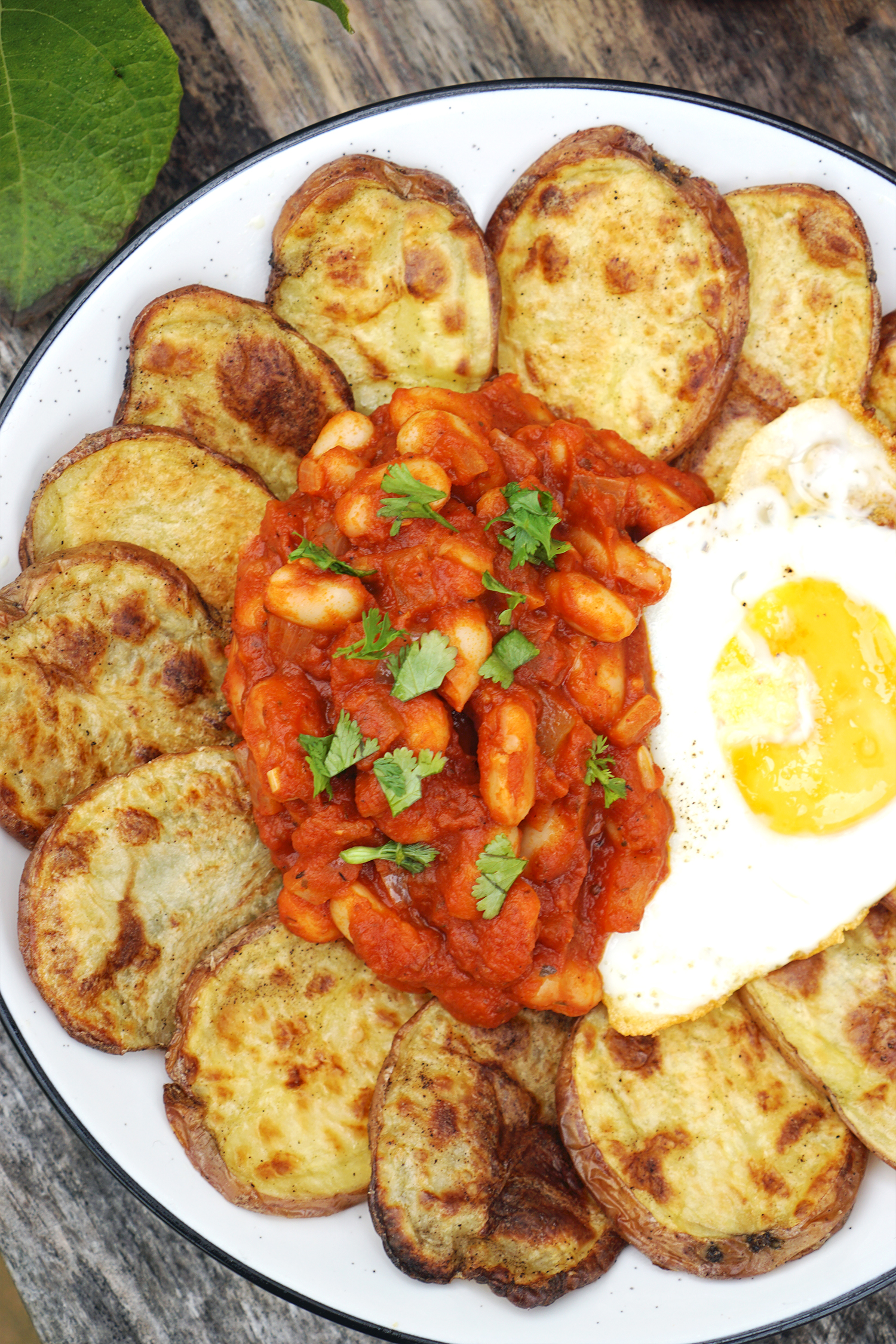 Homemade baked beans / white beans in tomato sauce served with cottage fried (baked potato slices) and a fried egg