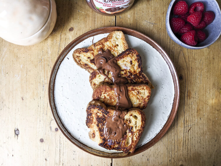4 gluten Free French toast with melted butter and Nutella on top + raspberries on the side / Made with Sainsbury's free from white bread